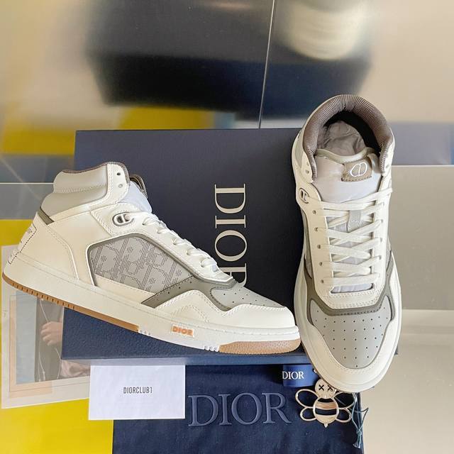 顶级版本 Dior迪奥b27系列情侣款老花休闲运动板鞋 这款 B27 高帮运动鞋是 Dior 的经典单品 采用奶油白色和灰白色光滑牛皮革精心制作 侧面饰以灰白色