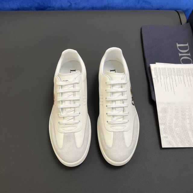 D～R 新款 B01 运动鞋是d家经典单品，鞋面采用原版牛皮绒面革以及由 Daniel Arsham 重新诠释的“Di*R”徽标装饰。鞋面顶部采用白色系带，与富